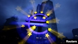 Подсвеченный символ евро у здания Европейского Центробанка во Франкфурте-на-Майне.