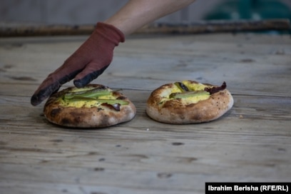 Kjo furrë nuk gatuan thjesht pitalka të zakonshme, ajo shton në to edhe përbërës të tjerë, sikurse në këtë fotografi ku shihen pitalka me speca të gjelbër dhe vezë.Çfarë e dallon këtë furrë me furrat e tjera është se, këtu, një myshteri mund ta porosisë gatimin e pitalkës sipas dëshirës së vet dhe t'ia dërgojë bukëpjekësit materialin e nevojshëm për ta bërë atë.