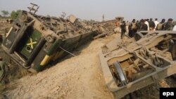 Security officials inspect the scene of a bomb blast that targeted the rail track in Kashmore, February 16, 2014