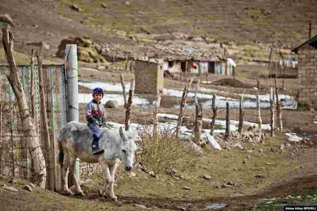 A boy rides a donkey in the village of Deman, near the Iranian border.