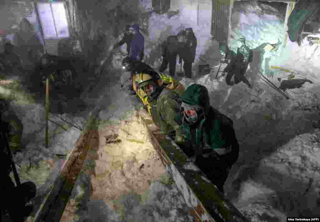 Спасатели МЧС России работают на месте схода лавины в районе Талнах города Норильска. Три человека погибли после того, как лавина прокатилась по горнолыжному курорту. (AFP/Ирина Яринская)