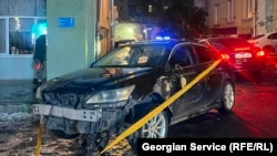 ავტომობილი ამ დროისთვის [18:30] ისევ სკოლის კიბეებთან დგას და მის ირგვლივ ყვითელი ლენტია გაბმული.