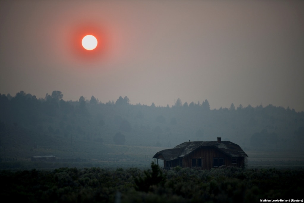 Një tym i dendur ka bërë që dielli të vezullojë ngjyrë të kuqe mbi një fermë të braktisur, pas përhapjes së një zjarri në Oregon të Shteteve të Bashkuara të Amerikës. (13 korrik)