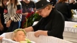 A relative mourns at the coffins of Yaroslav Bazylevych's family members during their funeral service in the Garrison Church in Lviv on September 6. Bazylevych's wife, Yevgenia, and their three daughters 0- Darina, 18, Emilia, 7, and Yaryna, 21 0- were killed in a Russian missile attack.