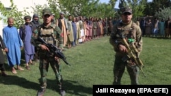 Afghan security officials present civilians who were released during an operation at a Taliban prison in Pashtun Zarghon district of Herat on May 25.