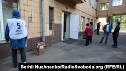 Учасник проведення опитування з картонною скринькою, на якій написано «5 питань від президента», 25 жовтня 2020 року