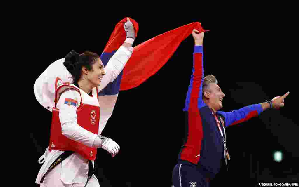 Міліца Мандич (зліва) із Сербії зі своїм тренером святкує&nbsp;перемогу над Дабін Лі з Південної Кореї. Вона виборола золоту медаль у змаганні тхеквондо&nbsp;серед жінок у ваговій категорії понад 67 кг. Японія, 27 липня 2021 року