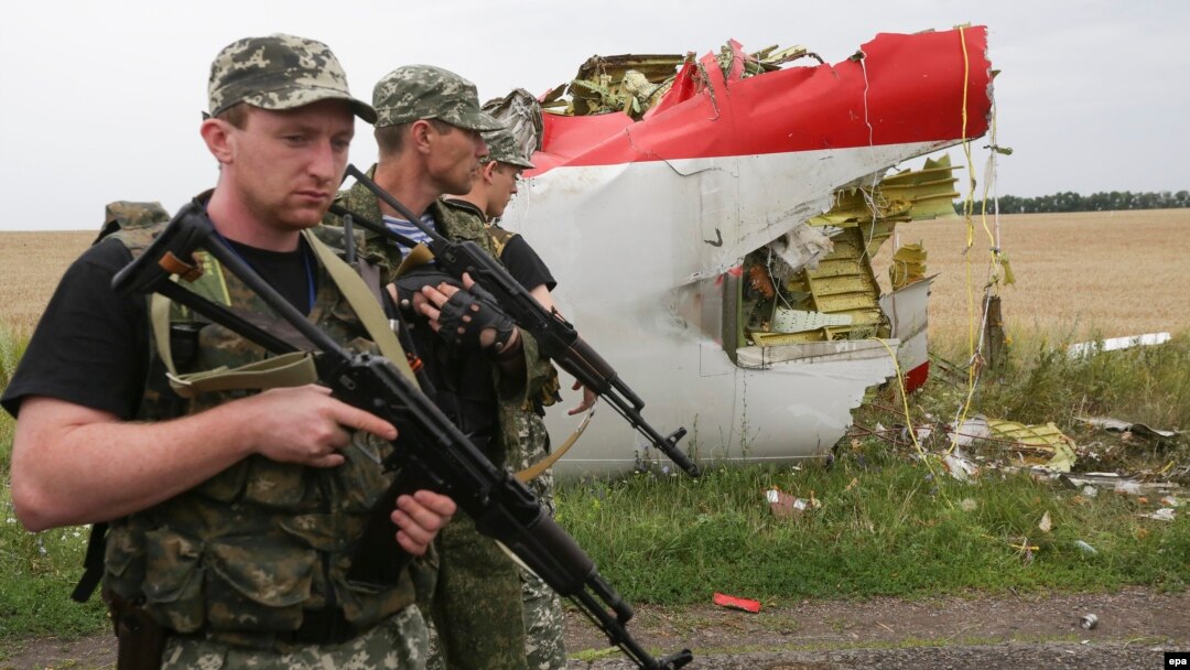Armed pro-Russia militants walk next to the wreckage of Flight MH17 in eastern Ukraine near Donetsk on July 18, 2014.
