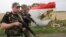 Armed pro-Russia militants walk next to the wreckage of Flight MH17 in eastern Ukraine near Donetsk on July 18, 2014.
