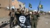 Iraqi soldiers and Shi'ite volunteers hold a flag belonging to the Islamic State extremist group after they regained control of Tikrit, April 1, 2015.