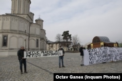 Protesters present a petition for changes to the baptism ritual to church officials in Bucharest on February 15.