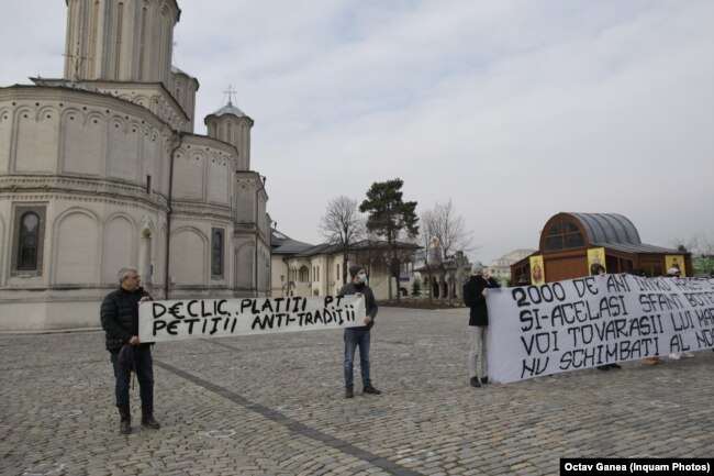 Protesters present a petition for changes to the baptism ritual to church officials in Bucharest on February 15.