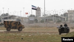 Turkish troops take up position at the Akcakale border gate in southern Sanliurfa province on the border with Syria on October 7.