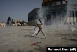 Un palestinian a fugit de gazele lacrimogene în timpul ciocnirilor cu forțele de ordine israeliene la moscheea Al Aqsa din orașul vechi din Ierusalim.