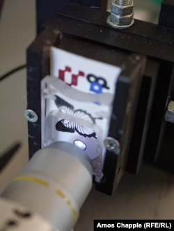 A Teslagram card inserted into a prototype reader. Inside the ink circle are several butterfly scales. The researchers hope to be able to sell Teslagram readers for around 100 euros ($115) each that could be used by museums, retail stores, or security companies.