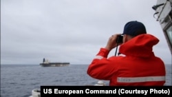 Припадник на крајбрежната стража на САД го гледа танкерот M/V Bella 1, кој беше запленет на 7 јануари 2025 година поради прекршување на санкциите на САД.