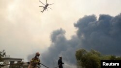 Vatrogasci pokušavaju da ugase požar u blizini sela Afidnes, sjeverno od Atine, Grčka, 6. augusta 2021.