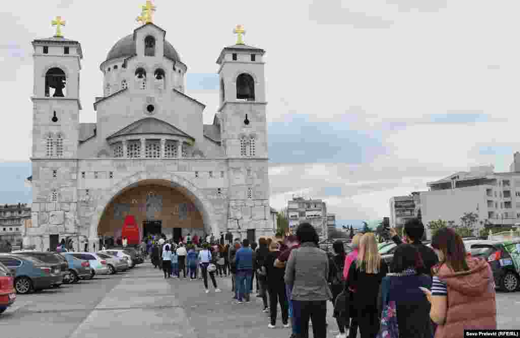 Ljudi čekaju u redu da prisustvuju liturgiji u crkvi Hristovog Vaskrsenja u Podgorici, Crna Gora.