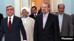 Armenian President Serzh Sarkisian (left) meets with Iran's parliament speaker, Ali Larijani, in Yerevan on October 9.