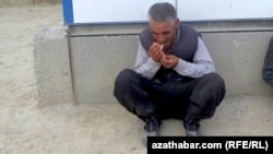 Köçede çilim çekýän adam