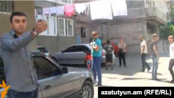 Armenia - A goverment loyalist protests at being filmed by RFE/RL correspondent Irina Hovhannisyan outside a polling station in Yerevan, 5May2013.