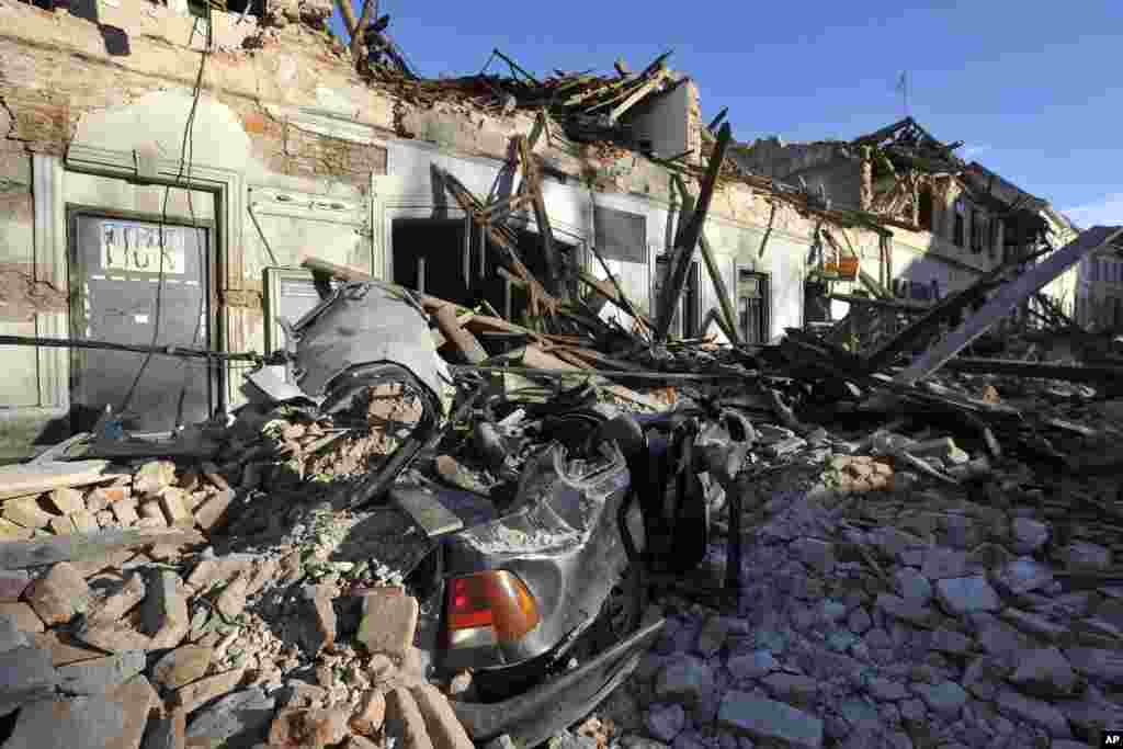 A view of remains of a car covered by debris and buildings damaged in an earthquake in Petrinja, Croatia, Tuesday, Dec. 29, 2020.&nbsp; (AP Photo)