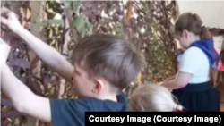 Дети плетут маскировочные сети в местном храме