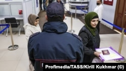 RUSSIA, NOVOSIBIRSK - MAY 31, 2024: A police officer and foreign nationals are seen at a migration service centre. 