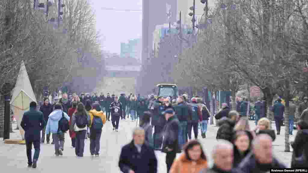 Disa qytetarë duke ecur në sheshin kryesor të Prishtinës. Specialistë të cilësisë së ajrit në Institutin Hidrometeorologjik të Kosovës – organ përgjegjës për cilësinë e ajrit – i kanë thënë më herët Radios Evropa e Lirë se periudha më kritike e ndotjes së ajrit në Kosovë është nga muaji nëntor e deri në shkurt.