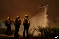 Apa este aruncată din elicopter peste incendiul Palisades din canionul Mandeville pe 11 ianuarie - Los Angeles.