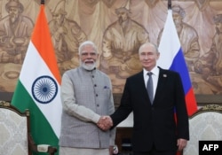 Russian President Vladimir Putin and Indian Prime Minister Narendra Modi shake hands during a meeting on the sidelines of the Shanghai Cooperation Organization (SCO) in Bishkek on August 31.