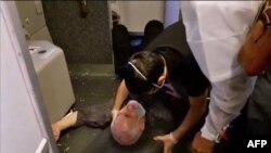An image grab from a video released by state-run Iran Press news agency on July 24, 2020, reportedly shows a crew member helping a passenger who fell over on an Iranian passenger plane after it was intercepted by a US F-15 while flying over Syria