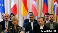 The European Union's political director Helga Schmid and Iranian deputy Foreign Minister Abbas Araghchi, from left, wait for a bilateral meeting as part of the closed-door nuclear talks with Iran at a hotel in Vienna, July 28, 2019