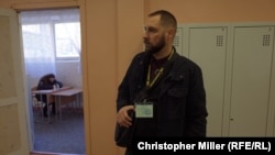 Yuriy Petrenko, a member of the National Militia, monitors voting at School No.14 in Podil, in Kyiv, on March 31.