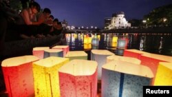 Candele plutitoare în memoria celor uciși de bomba atomică de la Hiroshima pe râul Motoyasu, în fața Domului Bombei Atomice, Hiroshima 6 august 2022.