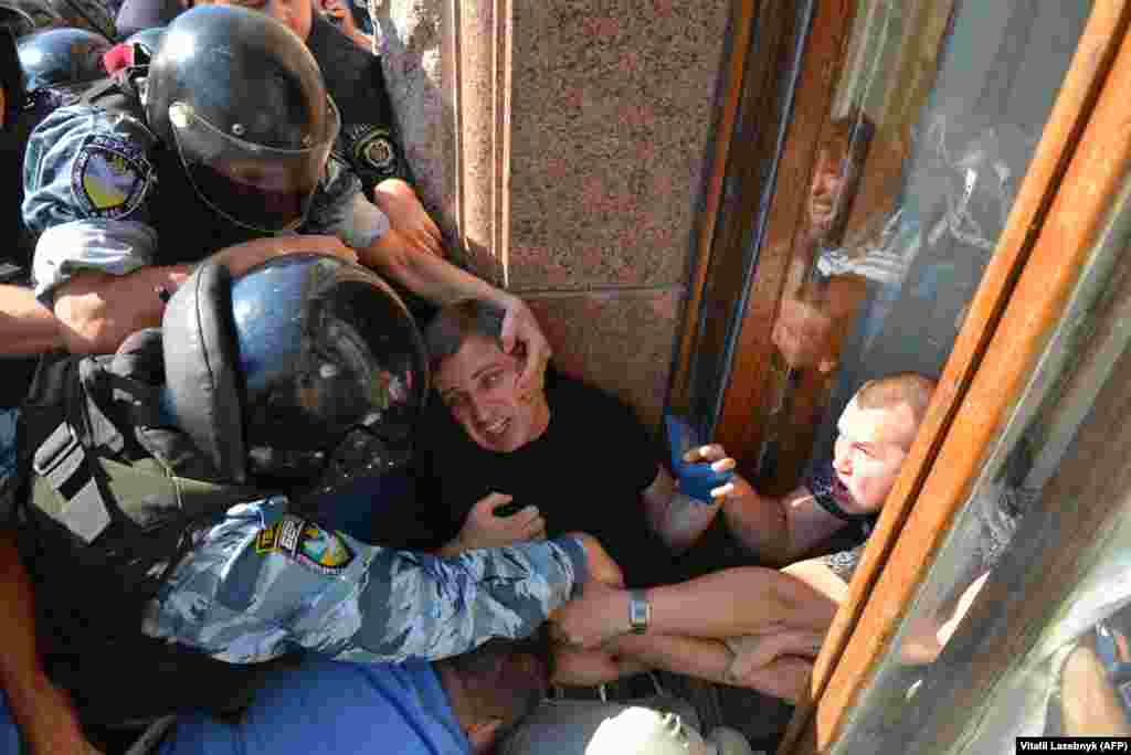 Riot police grapple with an opposition deputy trying to enter the Kyiv city council through a window in August 2013.&nbsp;