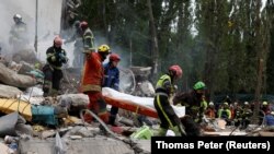 მაშველებს დაღუპული მშვიდობიანი მოქალაქის ცხედარი გააქვთ რუსული რაკეტებითა და დრონებით შეტევის შედეგად კიევში დანგრეული სახლიდან. 2025 წლის 31 ივლისი