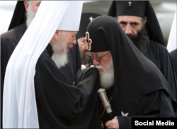 Патріарх Ілія під час візиту в Україну на ДеньХрещення Русі в 2011 році цілує на знак поваги руку митрополиту Володимиру, тодішньому предстоятелю УПЦ (МП)