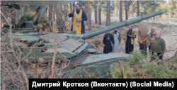 Священник РПЦ Дмитро Кротков освячує російський танк, що бере участь у так званій «спеціальній воєнній операції», тобто війні Росії проти України. Жовтень 2023 року