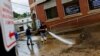 Members of the Fire Department clear debris from the street after heavy rains from storm Ida caused flooding in Oakdale, Pennsylvania.