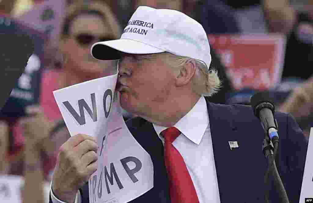 U.S. Republican presidential candidate Donald Trump kisses a &quot;Women for Trump&quot; placard during a rally in Florida on October 12. (AFP-Mandel)