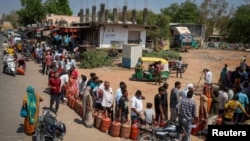 شماری از باشندگان شهر احمدآباد در هند که در انتظار تیل صف بسته اند