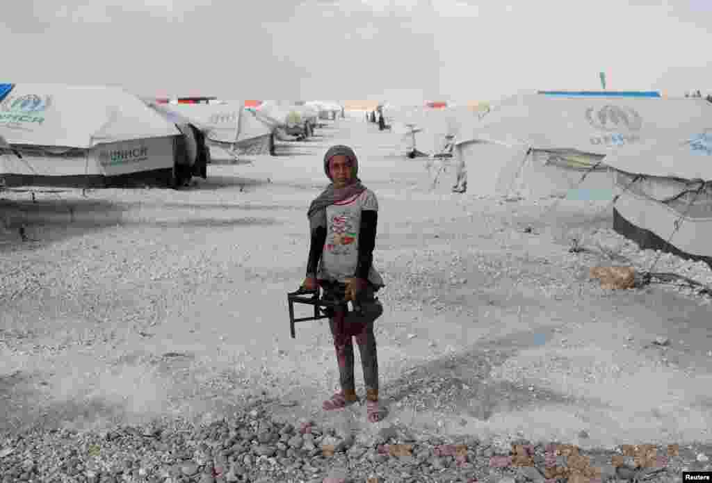 A teenager holds a cooker at a camp for people displaced by fighting in the Islamic State stronghold of Raqqa, Syria. (Reuters/Goran Tomasevic)