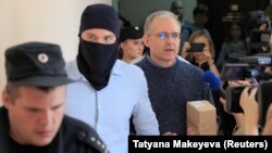 Paul Whelan (right), who was detained and accused of espionage, is escorted through a Moscow court building on August 23.