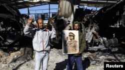 Сторонники Каддафи на месте разбомбленного склада военной техники в Триполи, 22 марта 2011