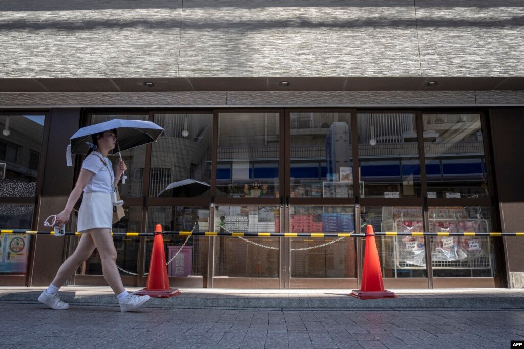 Një vajzë kalon pranë një dyqani të mbyllur në Fudhisava, prefektura Kanagava të Japonisë, më 30 korrik 2025.