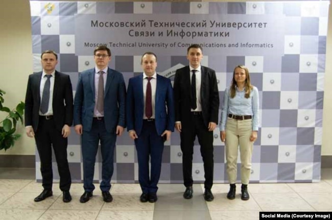 Në vitin 2021, Denis Obrezko (i dyti nga e djathta) foli në një universitet teknik në Moskë. Ai u identifikua si punonjës i Ministrisë së Situatave të Emergjencës.