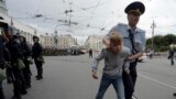 Un polițist escortează un adolescent care a participat la un protest în St. Petersburg, 9 septembrie 2018