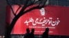 Tehran, Iran - People walk past a billboard with a picture of Iranian Major-General Qassem Soleimani, head of the elite Quds Force, who was killed in an air strike at Baghdad airport on January 3, 2020. 