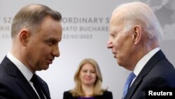 Presidenti i Polonisë, Andrzej Duda (majtas) duke e përshëndetur presidentin amerikan, Joe Biden, në Varshavë, shkurt 2023.